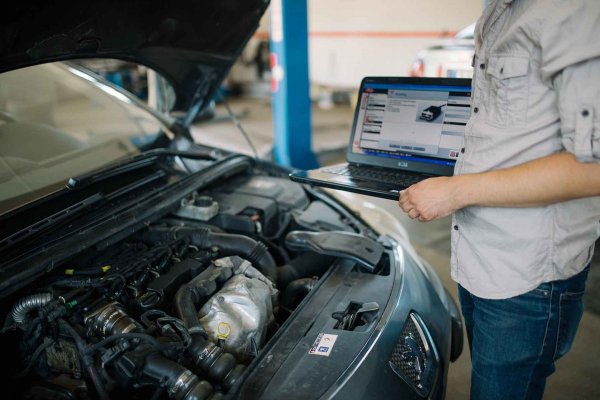 Mechanic with a laptop doing a car diagnostic