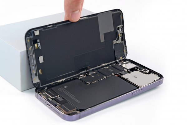 The display of an EU iPhone 14 Pro Max being opened and leaned against a white box.